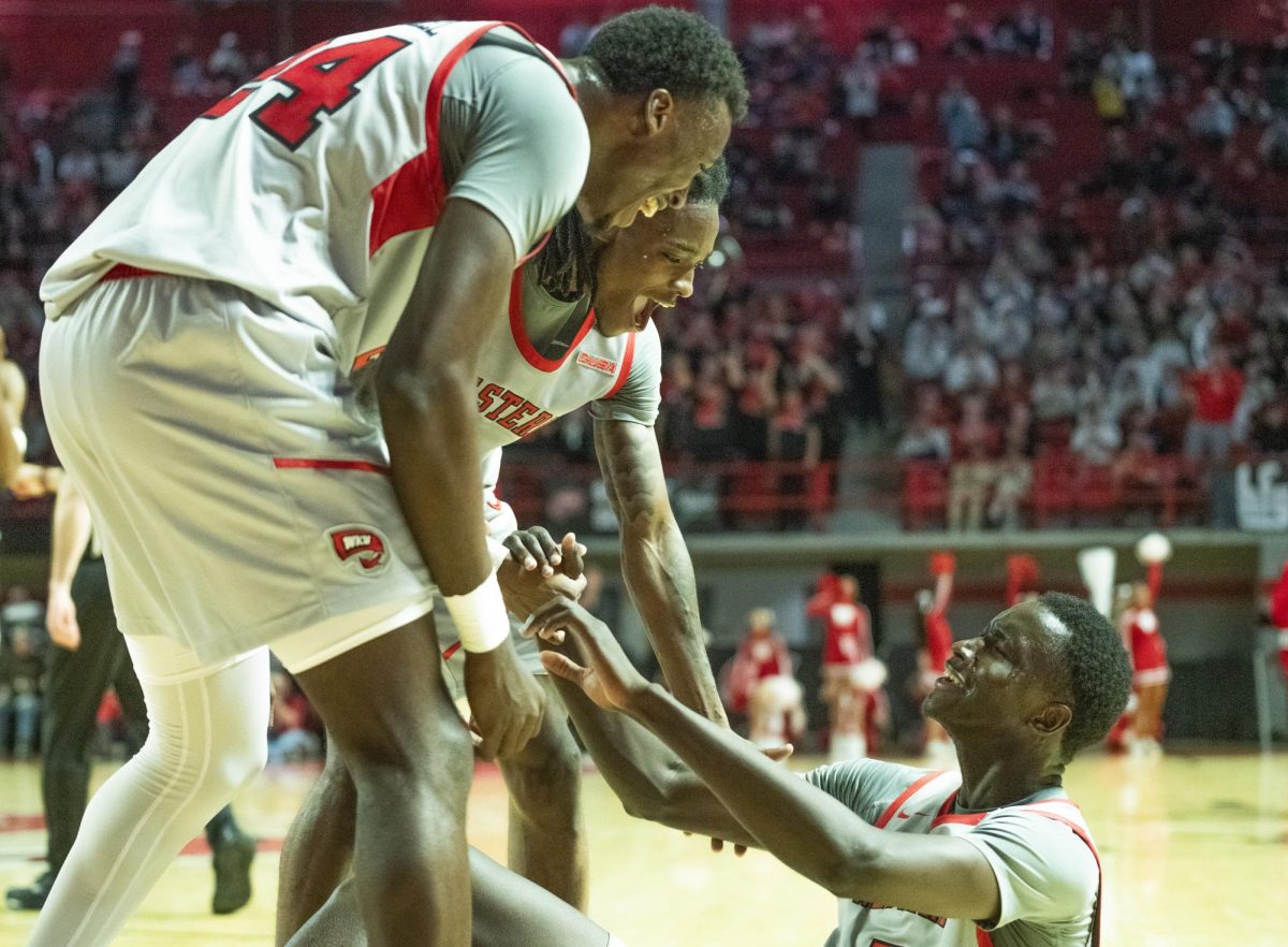 Tyrone Marshall (left), Don McHenry (middle), and Babacar Faye celebrate Faye's lay up during the second half of WKU's game against NMSU on Saturday, Feb. 17.