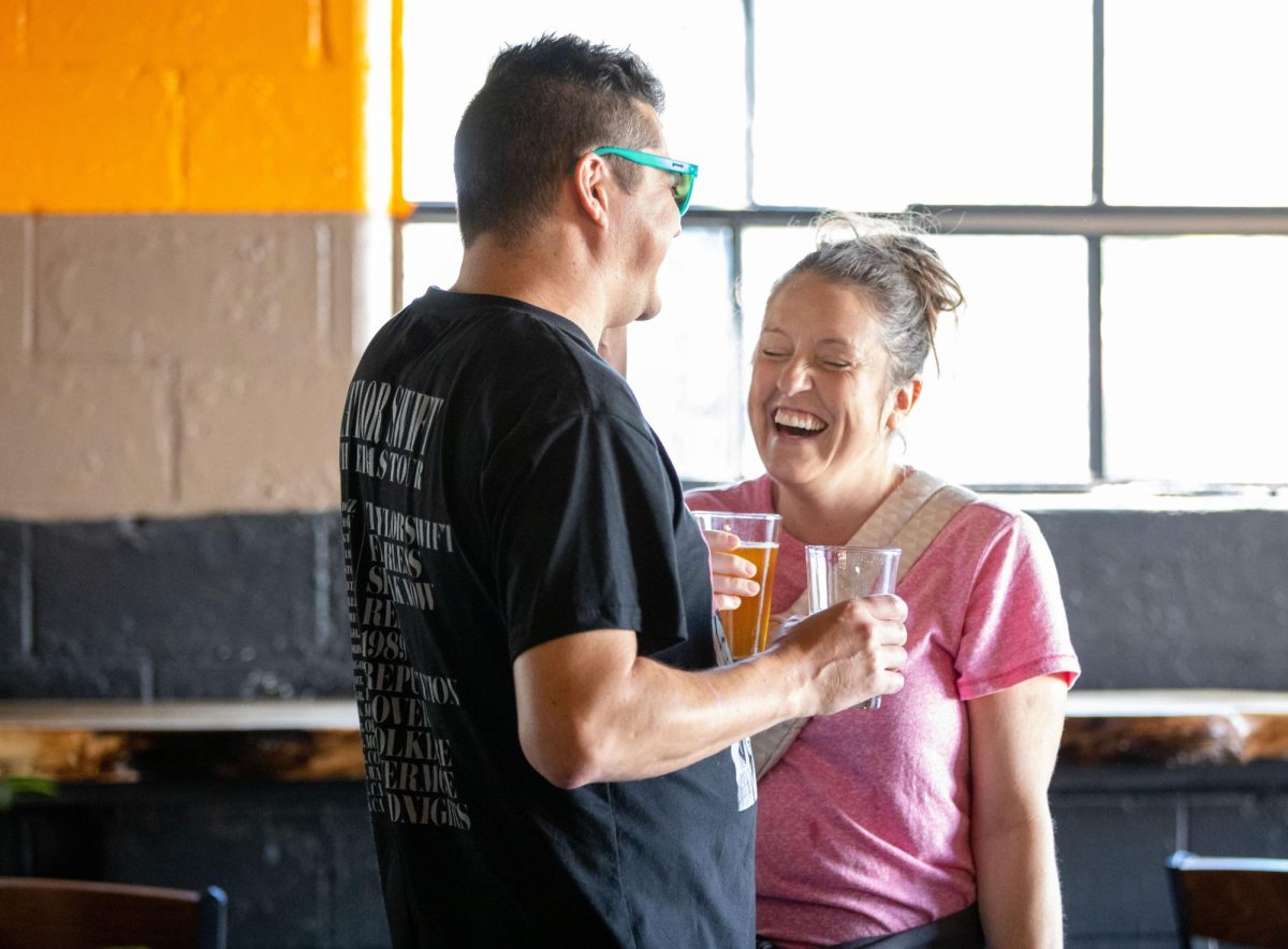 Blake Layne, left, and Katie Thompson laugh during the White Squirrel Brewery's Grand Opening  in Bowling Green on Saturday, Sept. 24, 2023. “I’m super excited for White Squirrel to be back,” Thompson said. 