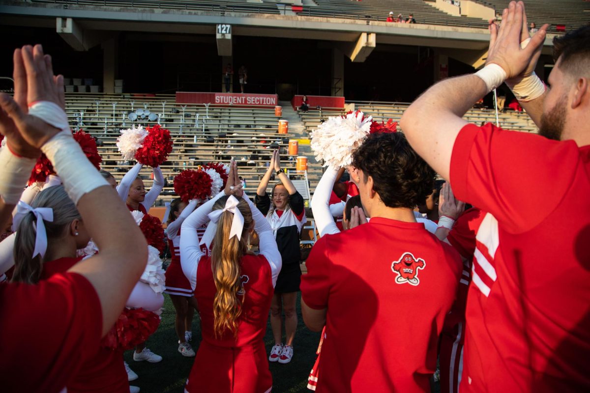 Cheerleaders meditate before a game against Middle Tennessee State University at L.T Smith Stadium in Bowling Green on Thursday, Sept. 28, 2023.