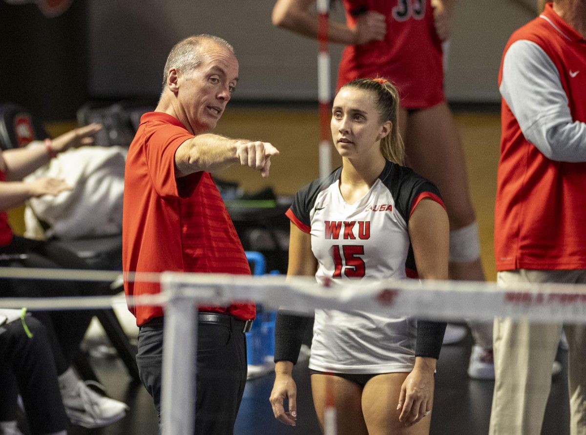 Western Kentucky University volleyball Head Coach Travis Hudson talks to defensive specialist Abby Schaefer (15) during a match against Middle Tennessee State University at Diddle Arena on Sunday, Oct. 8, 2024.  