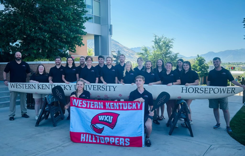 Faculty Advisor Jason Wilson (back row, left to right), Meaghan Czarnecki, Jaxson McAplin, Isabel Gray, Caleb Massey, Evan Brittenham, Cole Hollinsworth, Dylan Stephens, Ethan Newborn, Sophia Adams, Sarah Holt, Hunter Fred, Keeley McKnight, Leah Bell, Kaya Goertz, Carelynn Hartmann and Tyler Baker (faculty advisor) stand behind WKU's concrete canoe in Utah on June 20. Laken Moffitt (left) and Dylan Jackson hold the WKU flag. Photo provided by Dylan Stephens.