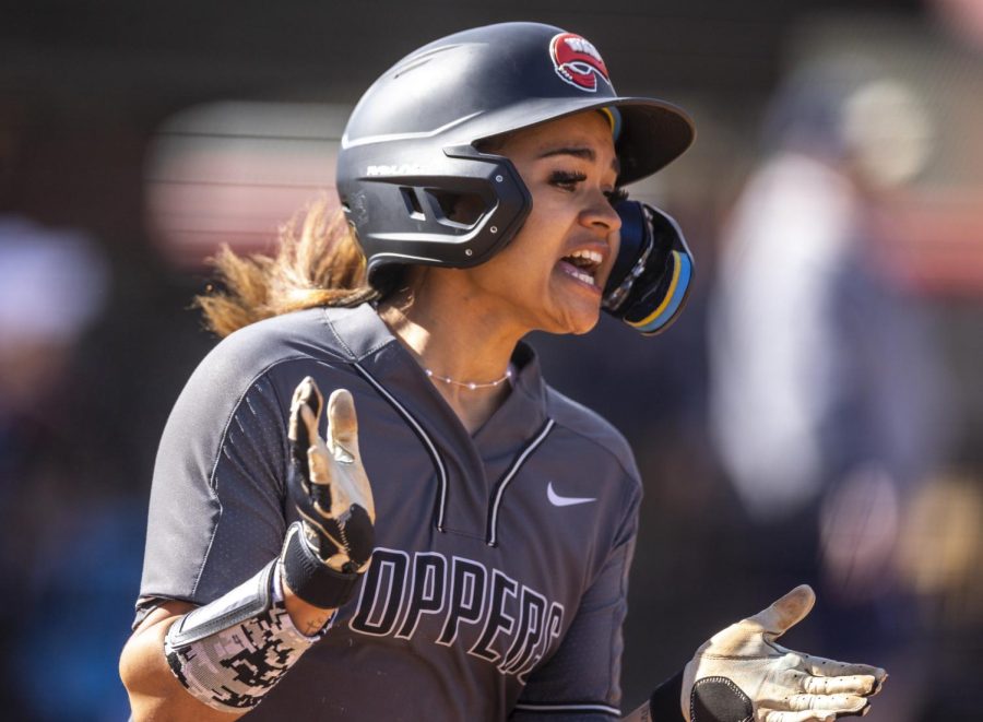 WKU outfielder Kasia Parks (4) celebrates scoring a point for the Hilltoppers while cheering on her teammate freshman utility Kaytlan Kemp (1) for hitting a triple during the game against the University of Akron at the WKU Softball Complex on March 5, 2023. WKU won 5-0.