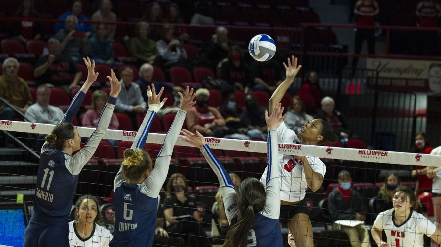 WKU Hilltoppers' senior middle hitter Lauren Matthews (5) spikes the ball over three Old Dominion players during the match on Oct. 28, 2021.