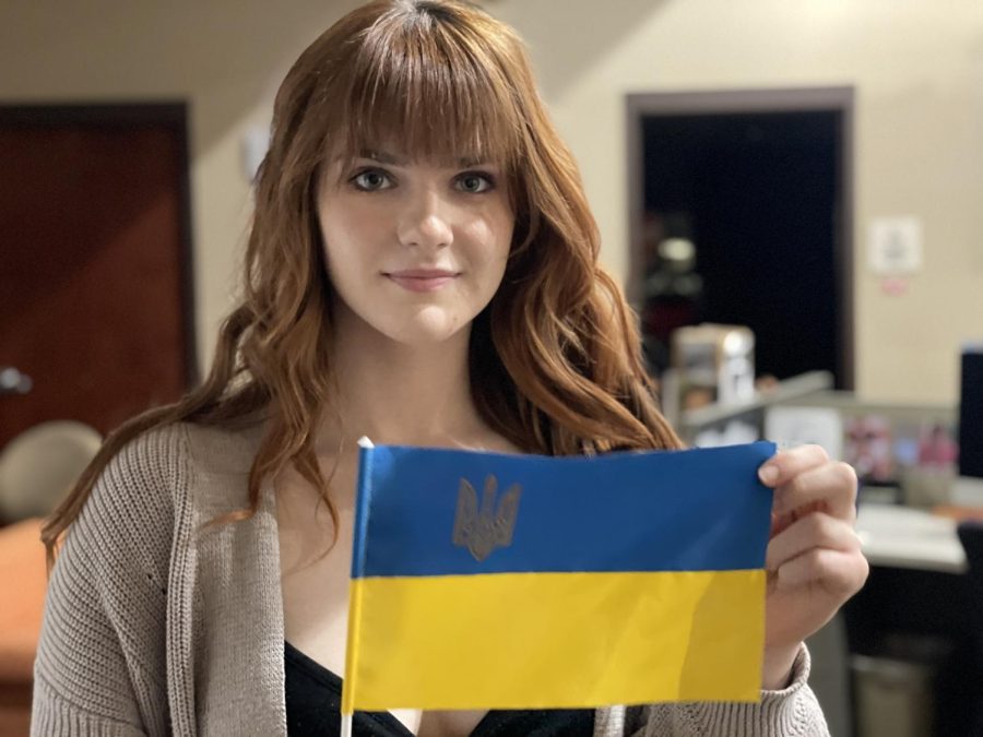 Julie Mishchuk poses with her flag, which she carries with her every day. Her mother brought it back a year ago from a trip to Ukraine.