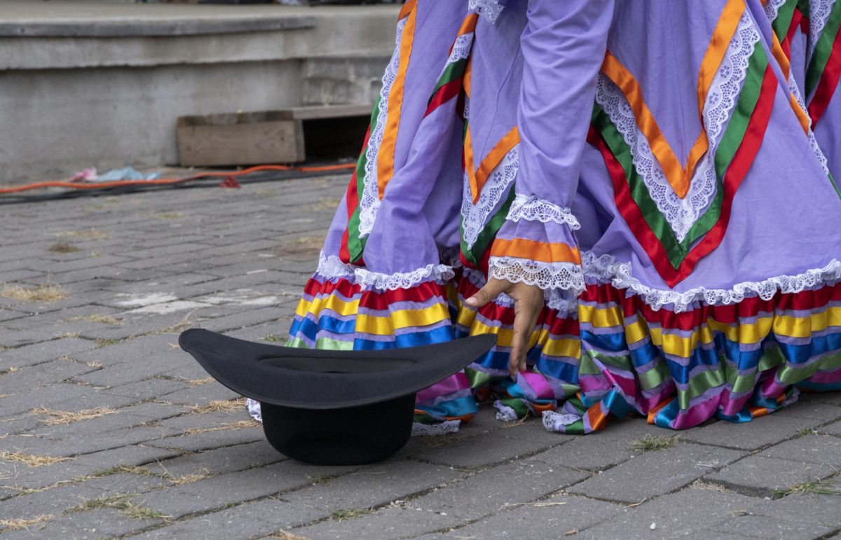 A female dancer retrieves Benjamin Rodriguez’s hat after his dance is finished at the BG Fiestaval in Bowling Green on Saturday, Sept. 14, 2024.