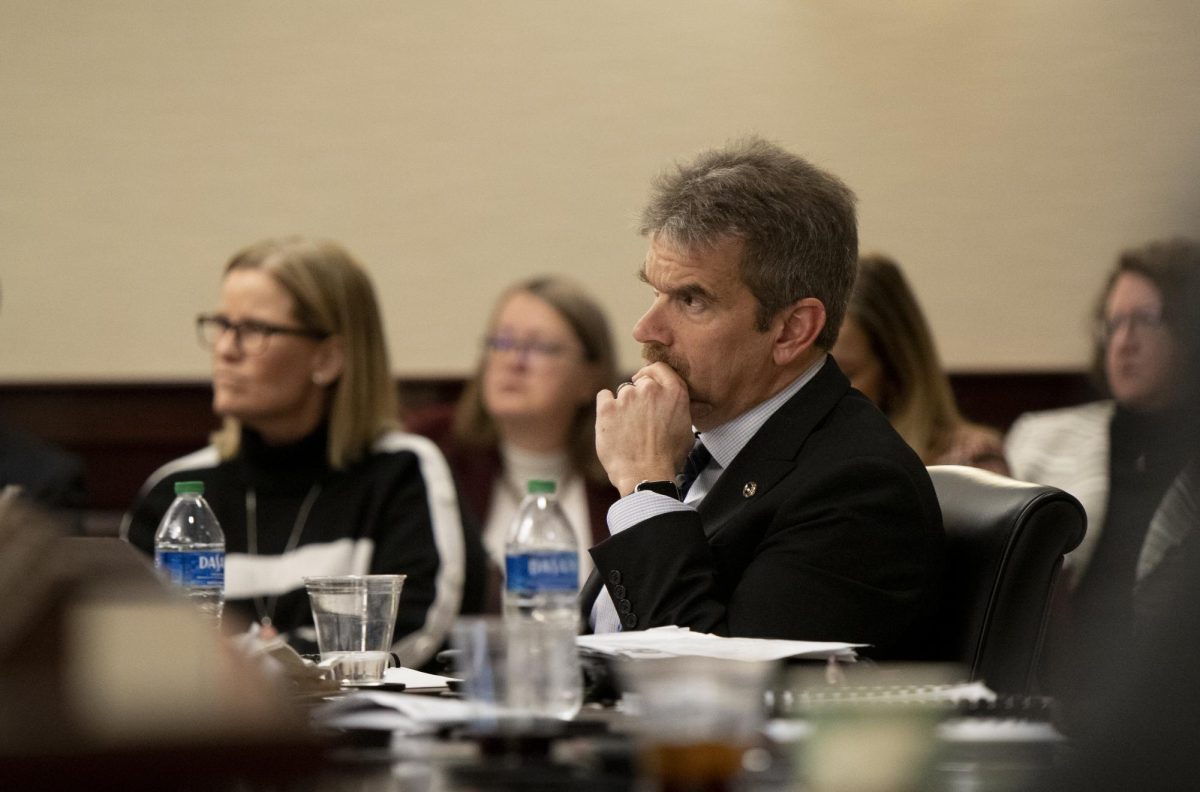Shane Spiller, faculty regent, listens to a presentation from CPA Partner Jennifer Williams on the NCAA compliance report during the Board of Regents' first quarterly meeting on Friday, March 1.