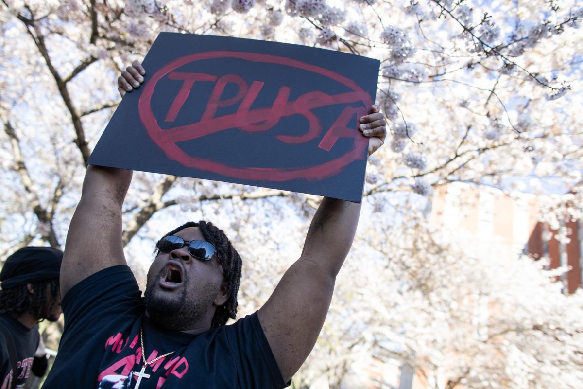 Protestor Devon Harrison holds a sign condemning the Turning Point USA organizations, whose WKU chapter invited Kyle Rittenhouse to speak earlier today outside of  Downing Student Union on March 27, 2024. 