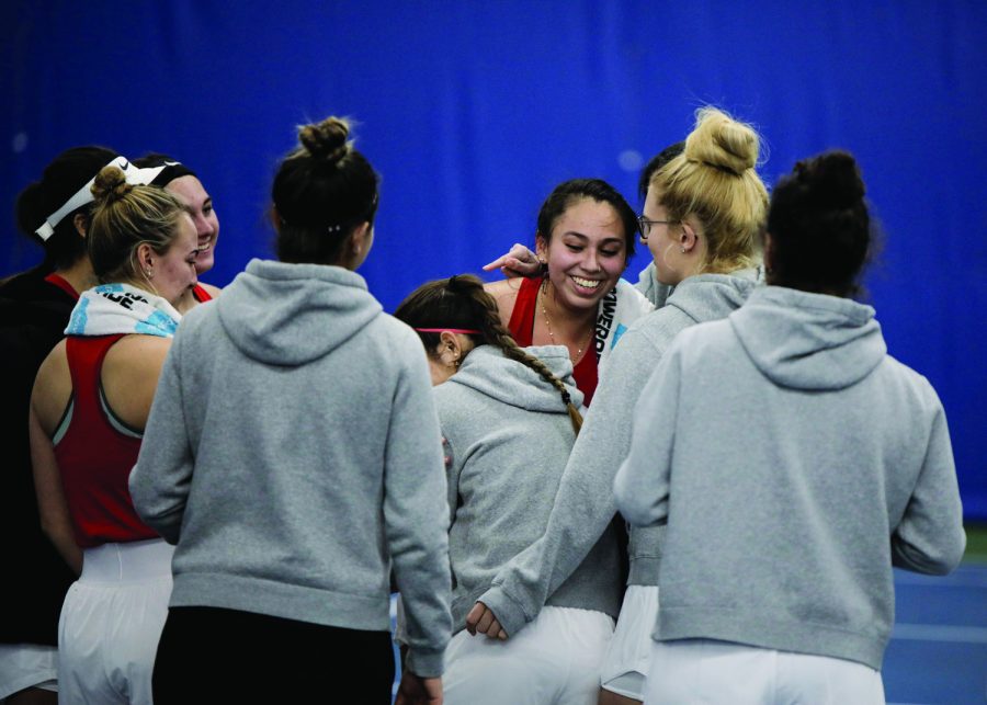 Western Kentucky University Hilltoppers women’s tennis team celebrate with redshirt sophomore Paola Cortez (center) after she won the last set in their match against Indiana University–Purdue University Indianapolis Jaguars on the afternoon of Sunday, Feb. 6, 2022, at Michael O. Buchanon Park’s tennis facility. WKU won the match 7-0.