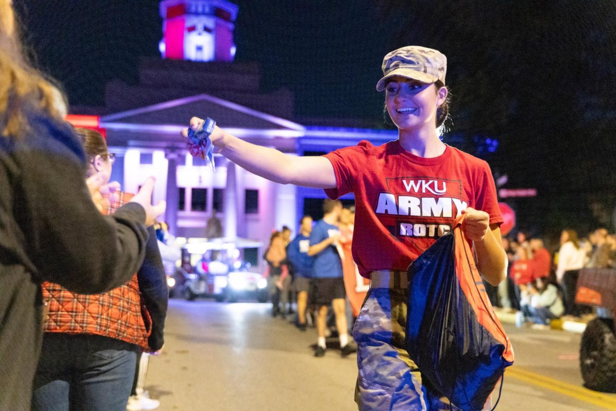 A WKU ROTC cadet hands out candy while walking in the Homecoming Parade on Nov. 10, 2023.