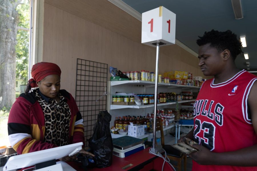 Sylvia Kamalebo checks out Lewis Abwe at Abby’s African International Market on May 16, 2023. Kamalebo owns Abby’s with her family, which is named after her daughter. Originally from Burundi in Africa, Kamalebo was a refugee and has lived in the U.S. for 15 years. Abby’s sells items from Africa, Mexico, Asia and the Caribbean. 